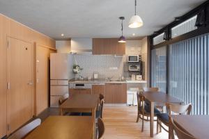 - une cuisine et une salle à manger avec des tables et des chaises en bois dans l'établissement Guest House Goettingen, à Kyoto