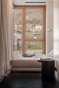 a bedroom with a bed and a large window at LA CASA DI LAURA in Valdobbiadene