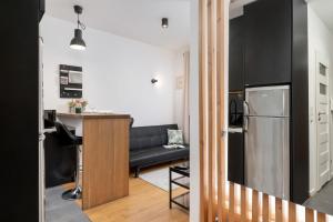 a kitchen and living room with a black couch at Cosy Ariańska Apartment for 3 in Cracow Center by Renters in Krakow