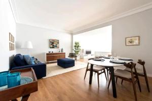 a living room with a table and a blue couch at Elegant and bright apartment in Estoril in Estoril