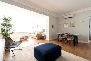 a living room with a table and a blue ottoman at Elegant and bright apartment in Estoril in Estoril