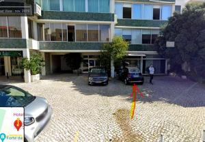 due auto parcheggiate in un parcheggio di fronte a un edificio di Elegant and bright apartment in Estoril a Estoril
