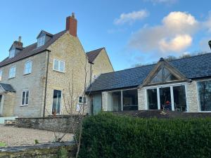 a large brick house with large windows at Luxury farmhouse in secluded Cotswold valley in Uley