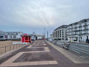 a boardwalk with a red building and buildings on the beach at Newly Refurbished 1 Bed Flat Southsea in Portsmouth