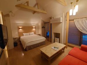 una camera d'albergo con letto e divano di Hotel Forest a Ōzu