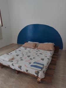 łóżko z niebieskim zagłówkiem i poduszkami w obiekcie Nungwi beach house II w mieście Nungwi