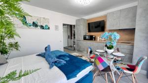 ein Schlafzimmer mit einem Bett und einem Tisch und Stühlen in der Unterkunft Cosmopolitan - Studio pe plaja cu vedere la mare & loc parcare gratis in Mamaia Nord – Năvodari