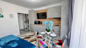ein Esszimmer mit Glastisch und Stühlen in der Unterkunft Cosmopolitan - Studio pe plaja cu vedere la mare & loc parcare gratis in Mamaia Nord – Năvodari + 4 Fotos
