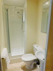 a bathroom with a shower and a toilet and a sink at Modern 2 Bed Apartment Close to Gla Airport & M8 in Paisley