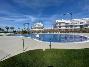 una gran piscina frente a un edificio en Costa Ballena - Dos dormitorios, Piscina y Jardín privado en Cádiz
