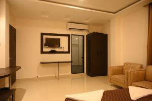 BishnāthHotel Tripti-Biswanath Chariali的客厅配有电视、沙发和椅子
