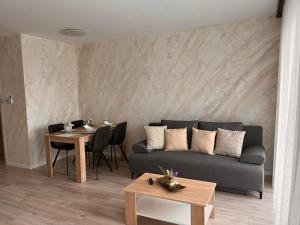 a living room with a couch and a table at Gréta Lux Apartman in Hajdúszoboszló