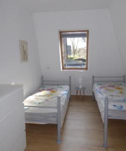 two twin beds in a room with a window at App. Weisses Haus in Hohen Neuendorf