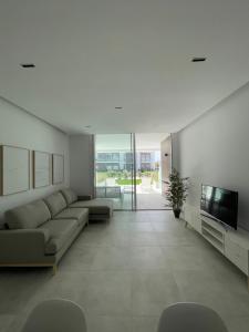 a living room with a couch and a tv at Costa Ballena - Dos dormitorios, Piscina y Jardín privado in Cádiz