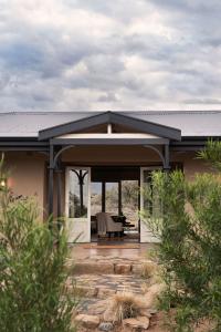 a house with a black roof and a patio at Samara Karoo Reserve in Graaff-Reinet