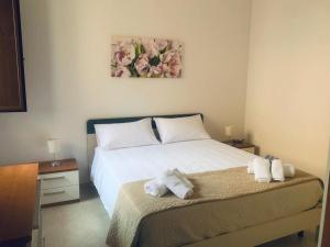 um quarto com uma cama branca com duas toalhas em Corte dei Fiori Acquaviva Apartments em Marittima