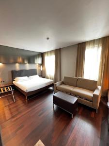 a large bedroom with a bed and a couch at Axolute Comfort Hotel Como - Cantù in Cantù