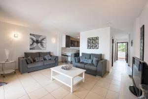 a living room with two couches and a table at Paloma Beach Apartments in Los Cristianos