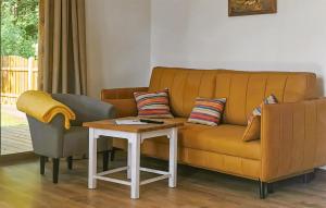 a living room with a yellow couch and a table at Beautiful Home In Kopalino With Wifi in Kopalino