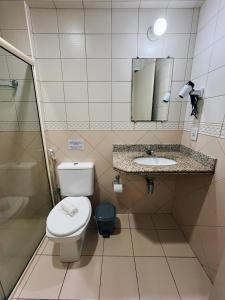 uma casa de banho com um WC, um lavatório e um chuveiro em Flat Exclusivo no Crystal Apart Hotel! em Macaé