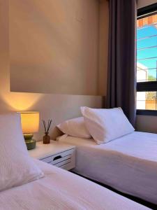 - une chambre avec deux lits, une fenêtre et une lampe dans l'établissement Casa Aurora ~ A Modern, welcoming apartment, à Jávea