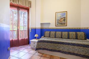 Un dormitorio con una cama con paredes azules y una ventana en Maiori Apartment with terrace and sea view, en Maiori