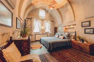 ein Schlafzimmer mit einem Bett und einem Sofa in einem Zimmer in der Unterkunft Kale Konak Cappadocia in Uchisar