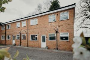 ein Backsteingebäude mit weißen Türen und Fenstern in der Unterkunft Sophisticated 2BR retreat for Contractors in charming Hinckley in Hinckley