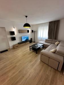 un soggiorno con un divano e una TV di New Bazaar Studios a Tirana Altre 26 foto