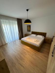 een slaapkamer met een bed en een hanglamp bij New Bazaar Studios in Tirana