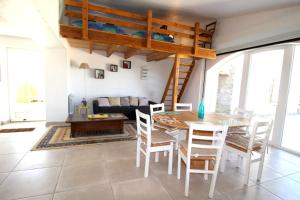 ein Wohnzimmer mit einem Tisch und einem Hochbett in der Unterkunft Maison avec jardin à Villeneuve-de-Berg, piscine partagée in Villeneuve-de-Berg