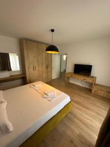 een slaapkamer met een groot bed en een televisie bij New Bazaar Studios in Tirana