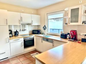 une cuisine avec des armoires blanches et un comptoir dans l'établissement 1006 - Haus Seesternweg, à Dahme