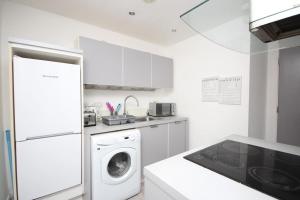 een witte keuken met een wasmachine bij Lovely 1 bed, located in the heart of Birmingham in Birmingham