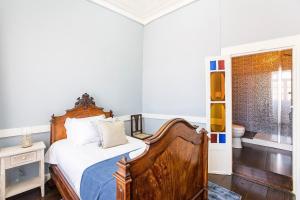 a bedroom with a wooden bed and a bathroom at Veloso Village Douro Valley by LovelyStay in Viseu