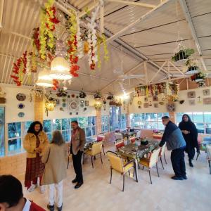 a group of people in a restaurant with tables and chairs at West View Hotel in Rānīkhet +29 photos