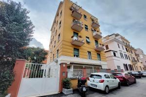 a white car parked in front of a yellow building at 4BNB - Ponte Milvio Apartment in Rome