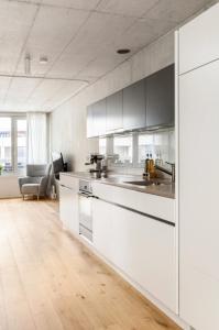 eine Küche mit weißen Schränken und einer Arbeitsplatte in der Unterkunft Designer-Maisonette im Industrie Chic 3,5 Zimmer in Zürich
