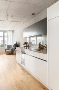 cocina con armarios blancos y encimera en Designer-Maisonette im Industrie Chic 3,5 Zimmer en Zúrich