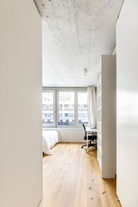 a bedroom with white walls and a bed and a desk at Designer-Maisonette im Industrie Chic 3,5 Zimmer in Zurich