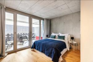 una camera con un grande letto e un balcone di Designer-Maisonette im Industrie Chic 3,5 Zimmer a Zurigo