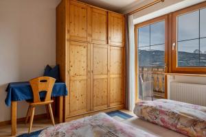 a bedroom with a bed and a table and a window at Malsötscherhof Apt B in Villandro