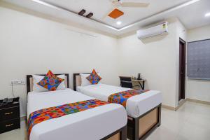 2 Betten in einem Zimmer mit weißen Wänden in der Unterkunft Sree Karthikeya Suites in Hyderabad