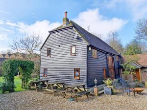 une grande maison avec des tables de pique-nique devant elle dans l'établissement Sussex Barns - Horsham, à Horsham