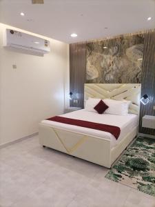 MY HOTEL AL YAQOT 3 POOLS VILLA - NIZWA في نزوى‎: غرفة نوم بسرير كبير عليها لوحة على الحائط