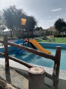 um parque infantil com escorrega numa piscina em MY HOTEL AL YAQOT 3 POOLS VILLA - NIZWA em Nizwa