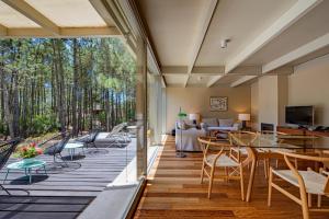 eine Terrasse mit Stühlen und Tischen und ein Wohnzimmer in der Unterkunft Pestana Troia Eco-Resort & Residences in Troia