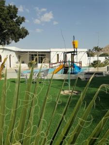 MY HOTEL AL YAQOT 3 POOLS VILLA - NIZWA في نزوى‎: حديقة بها ملعب وزحليقة