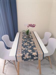 una mesa de comedor con un mantel con flores. en MY HOTEL AL YAQOT 3 POOLS VILLA - NIZWA, en Nizwa