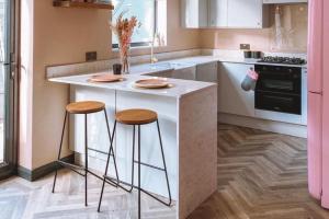 a kitchen with a white island with two stools at Kelun accomodations in Nairobi